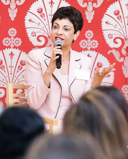 Shelmina holding a mic while speaking on stage